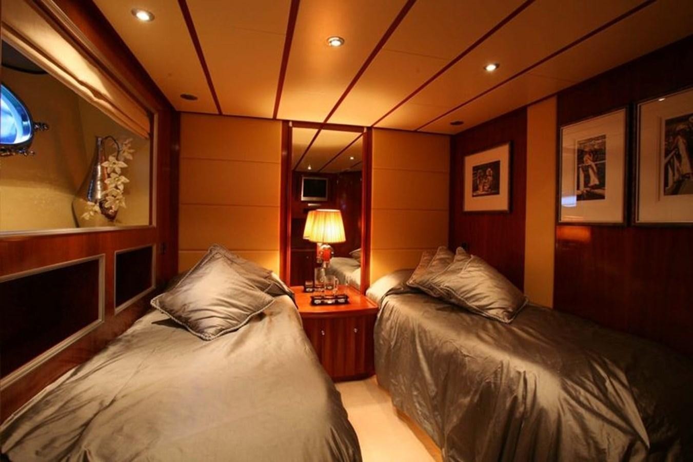a bedroom with a bed and a lamp aboard NAUGHTY BY NATURE Yacht for Sale