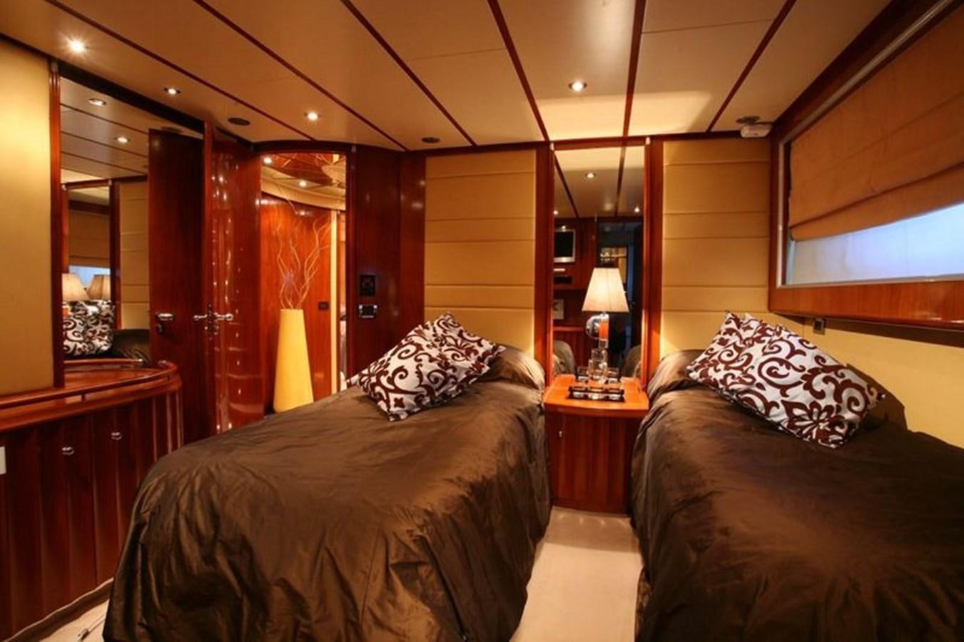 a bedroom with a bed and a lamp aboard NAUGHTY BY NATURE Yacht for Sale