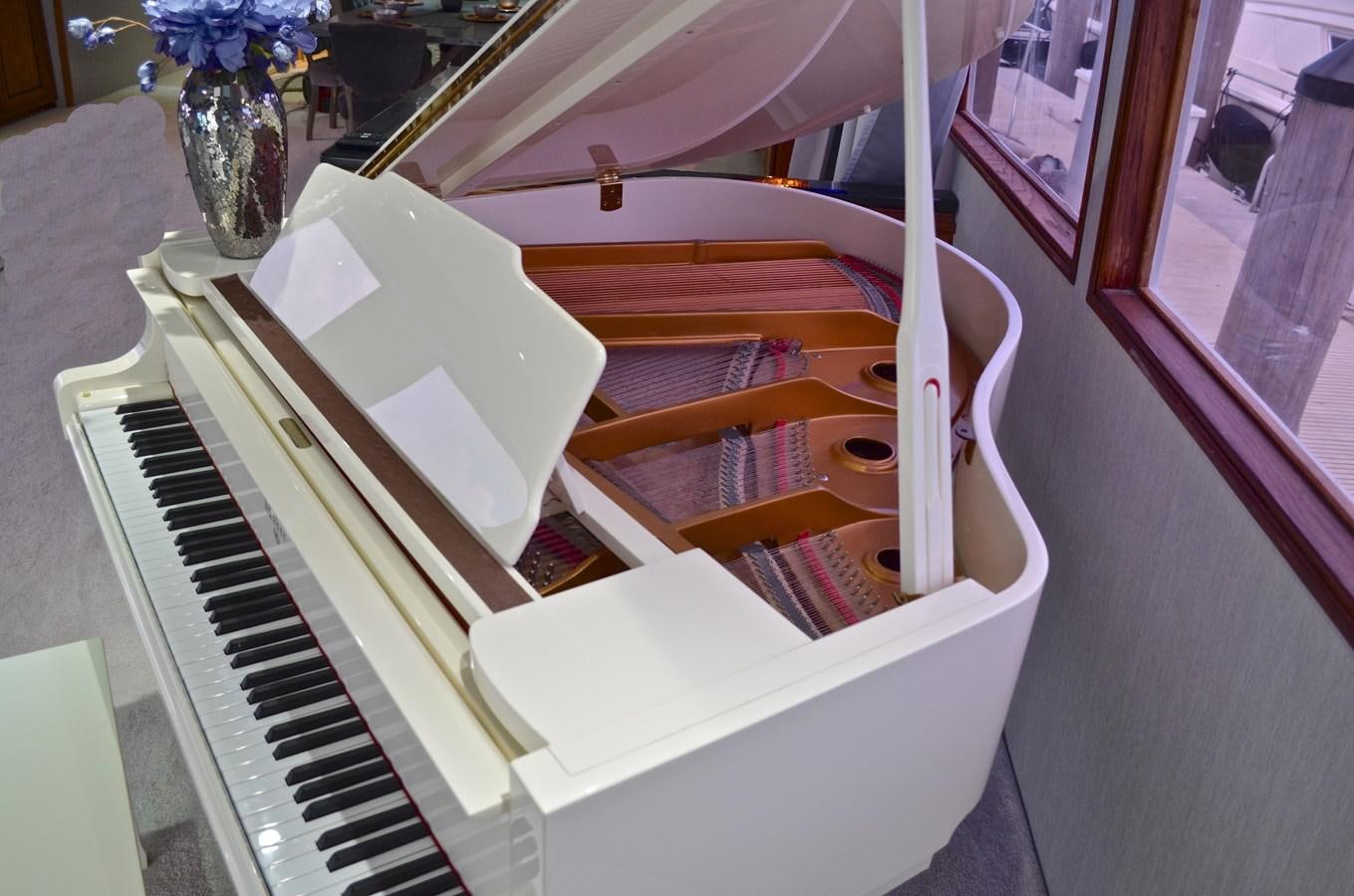 a piano with a stack of books on it aboard ISABELLA Yacht for Sale