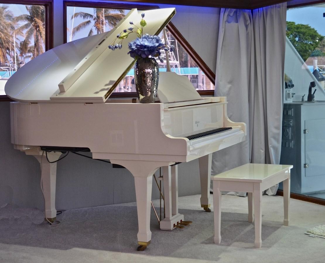 a white piano with a flower vase on top of it aboard ISABELLA Yacht for Sale