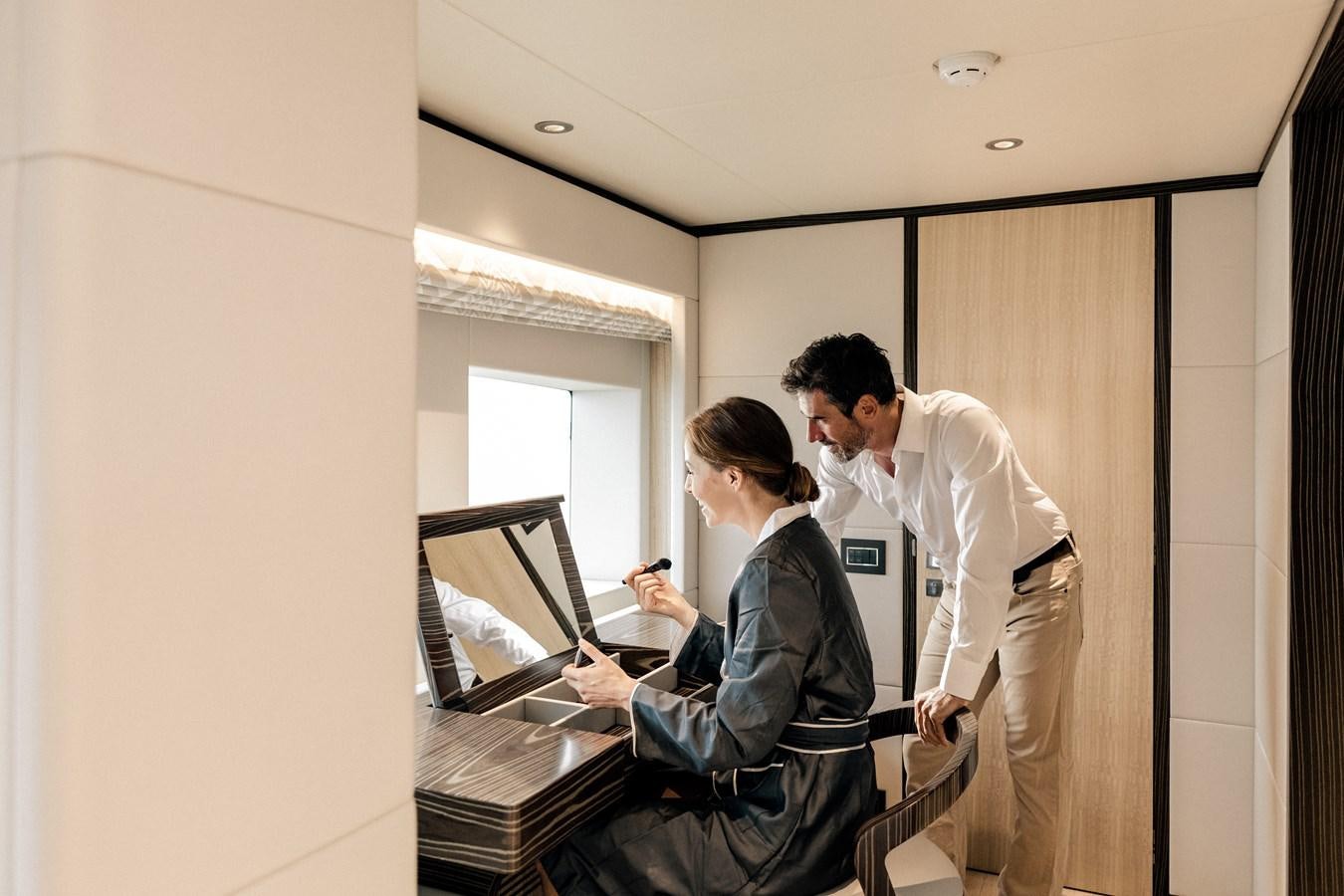 a man and a woman looking at a laptop aboard LEGACY Yacht for Sale