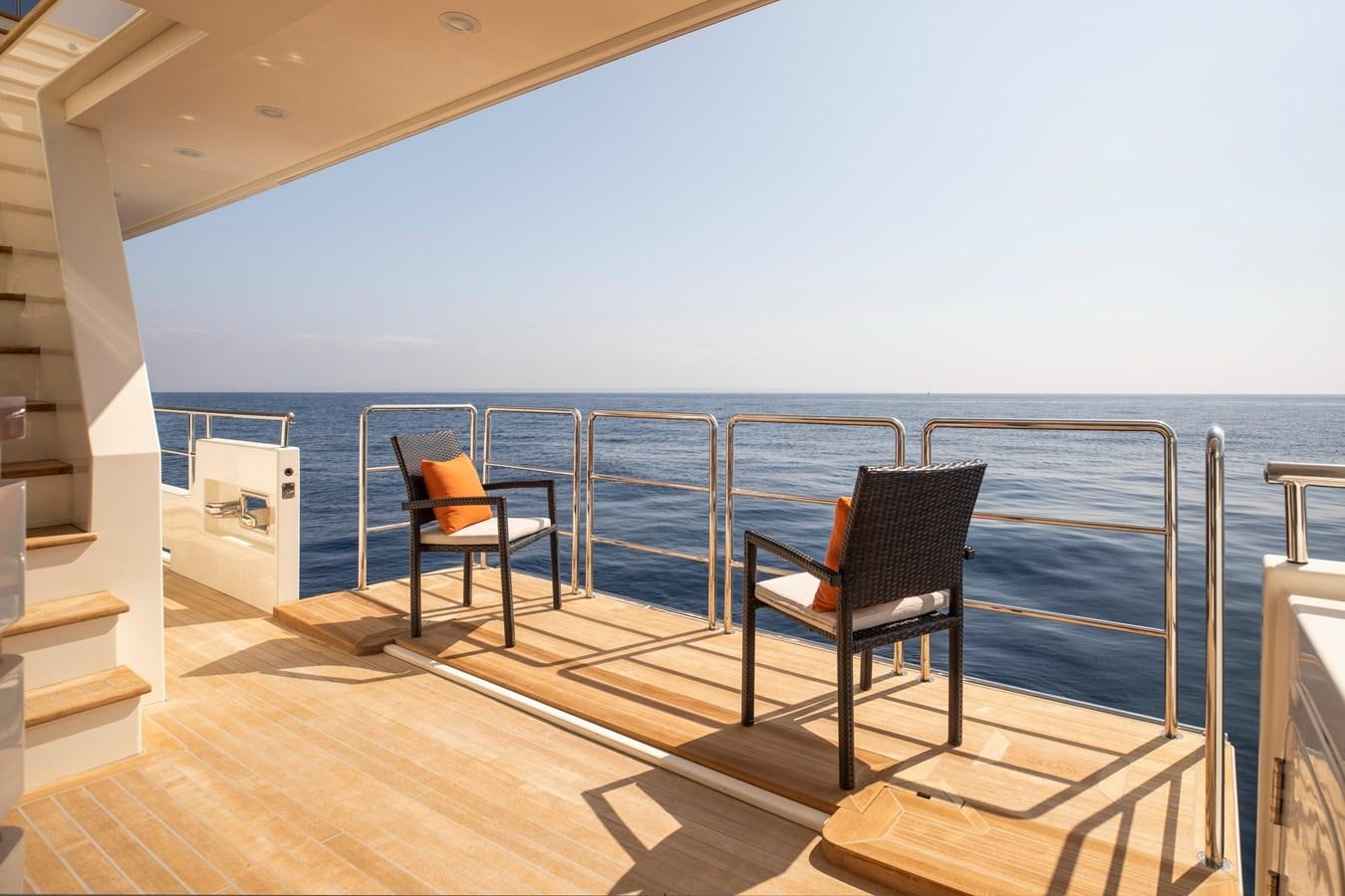 a deck with chairs and a view of the ocean aboard OCEAN DREAM Yacht for Sale