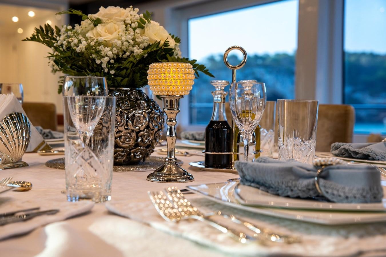 a table with plates and glasses aboard OCEAN DREAM Yacht for Sale