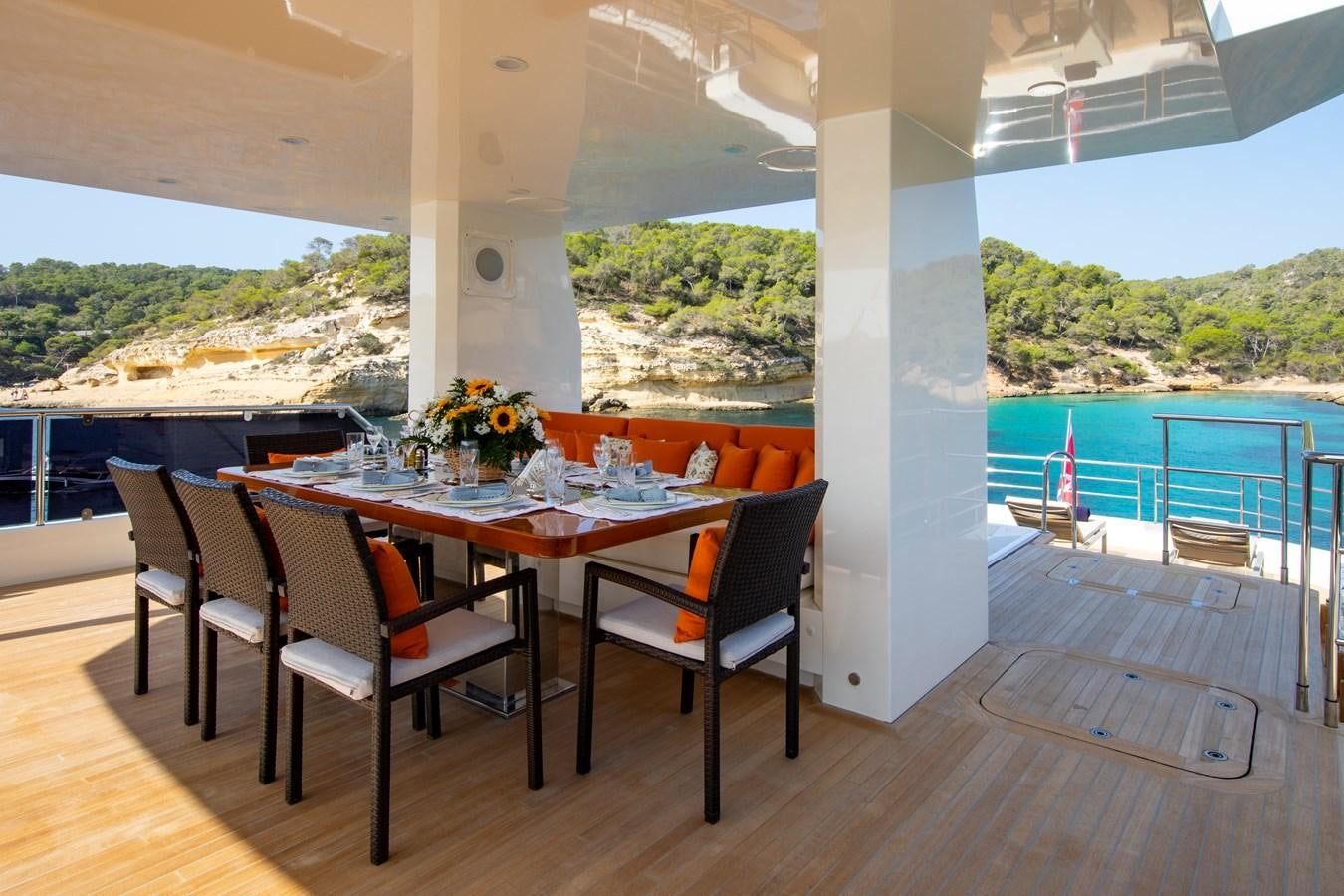 a table and chairs on a deck overlooking a body of water aboard OCEAN DREAM Yacht for Sale