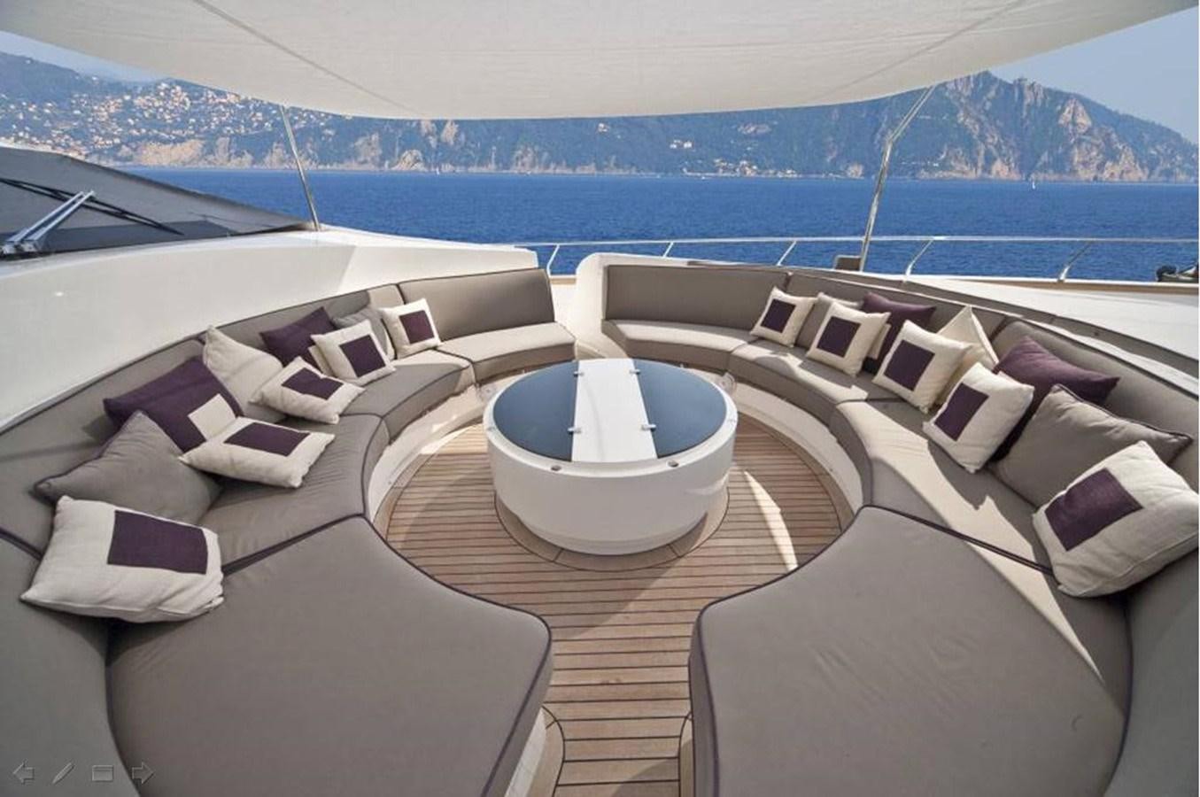 a large lounge area with a large pool and a large city in the background aboard TOBY Yacht for Sale