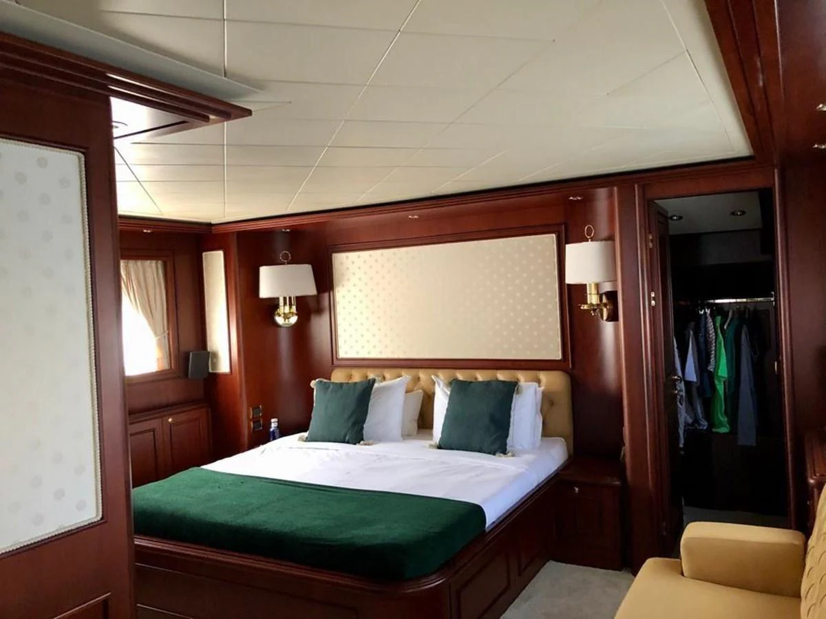 a bed with green sheets aboard GIHRAMAR Yacht for Sale