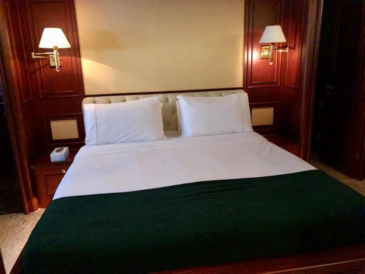 a bed with a green comforter aboard GIHRAMAR Yacht for Sale