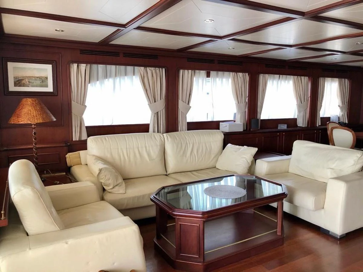 a living room with a table and couches aboard GIHRAMAR Yacht for Sale