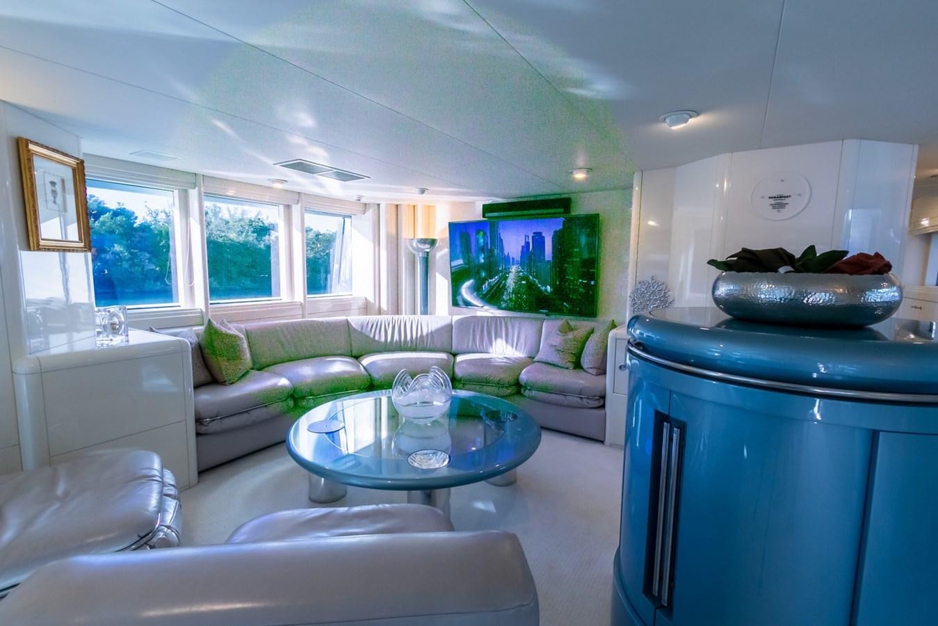 a living room with a large blue table and white couches aboard HIGH LINE Yacht for Sale