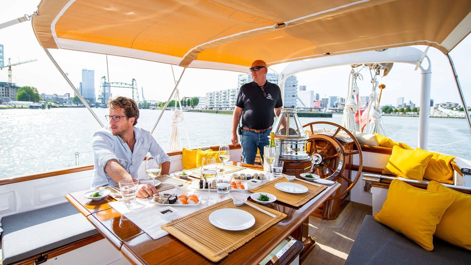 a couple of men sitting at a table on a boat aboard BORKUMRIFF II Yacht for Sale