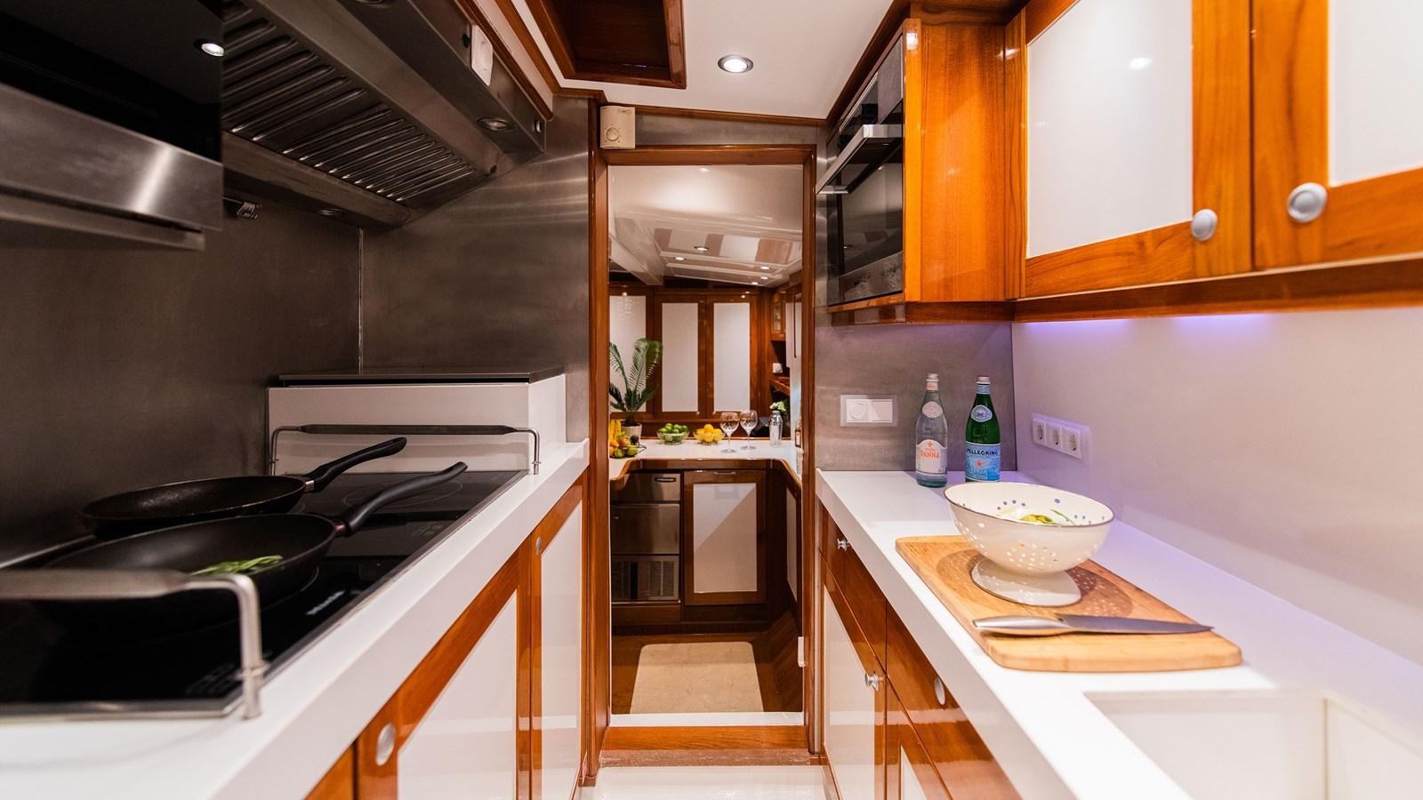a kitchen with wooden cabinets aboard BORKUMRIFF II Yacht for Sale