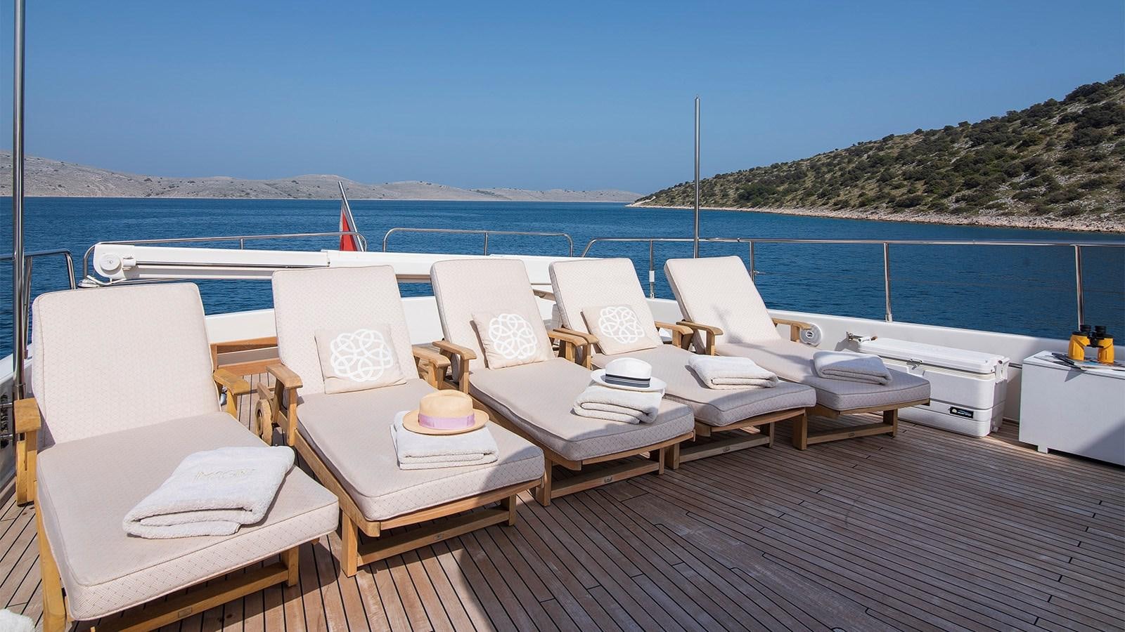 a group of chairs on a deck overlooking a large body of water aboard IMAGINE Yacht for Charter