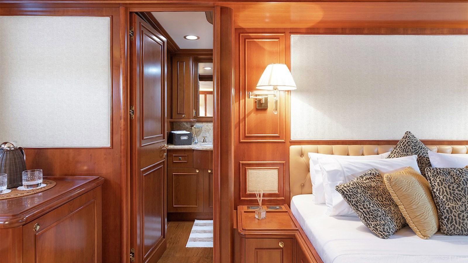 a bedroom with a bed and a lamp aboard IMAGINE Yacht for Charter