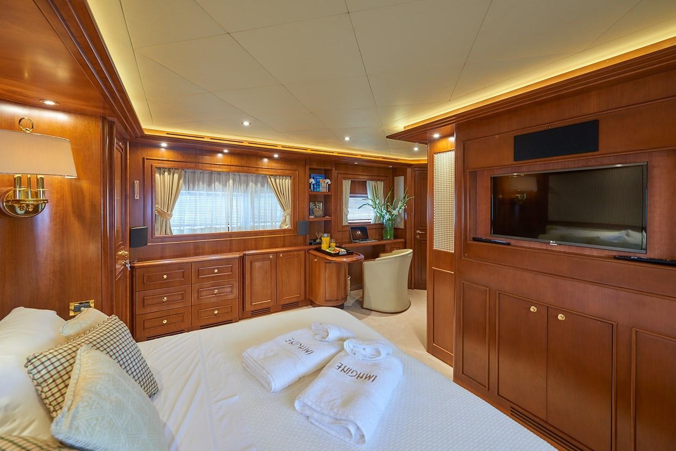 a bedroom with a bed and a television aboard IMAGINE Yacht for Charter