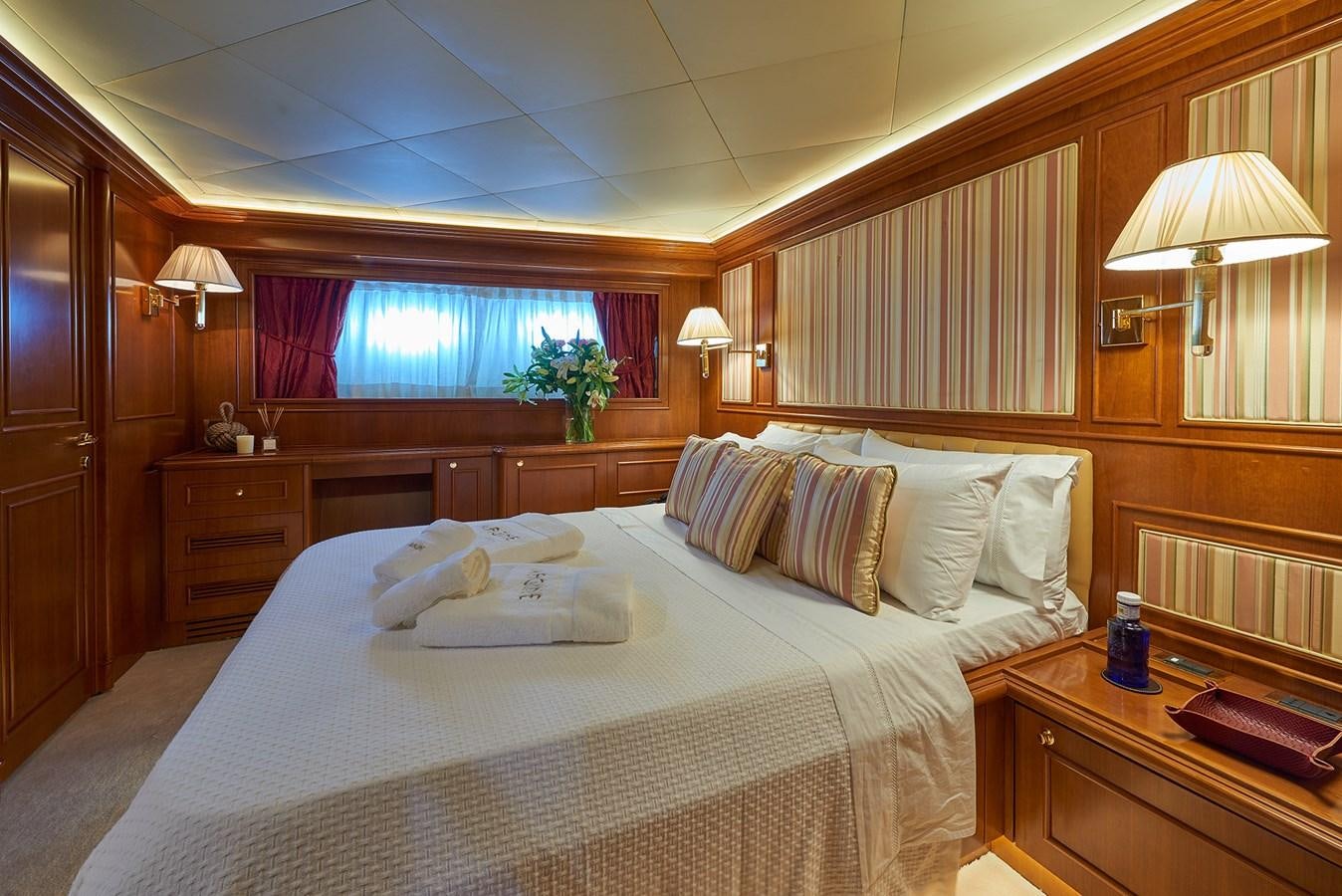 a bed with white sheets and pillows aboard IMAGINE Yacht for Charter