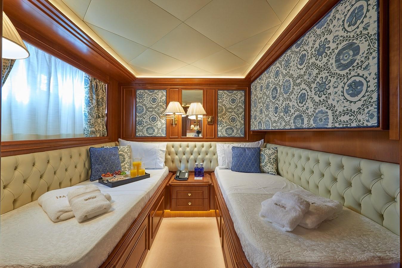 a room with a bed and a window aboard IMAGINE Yacht for Charter