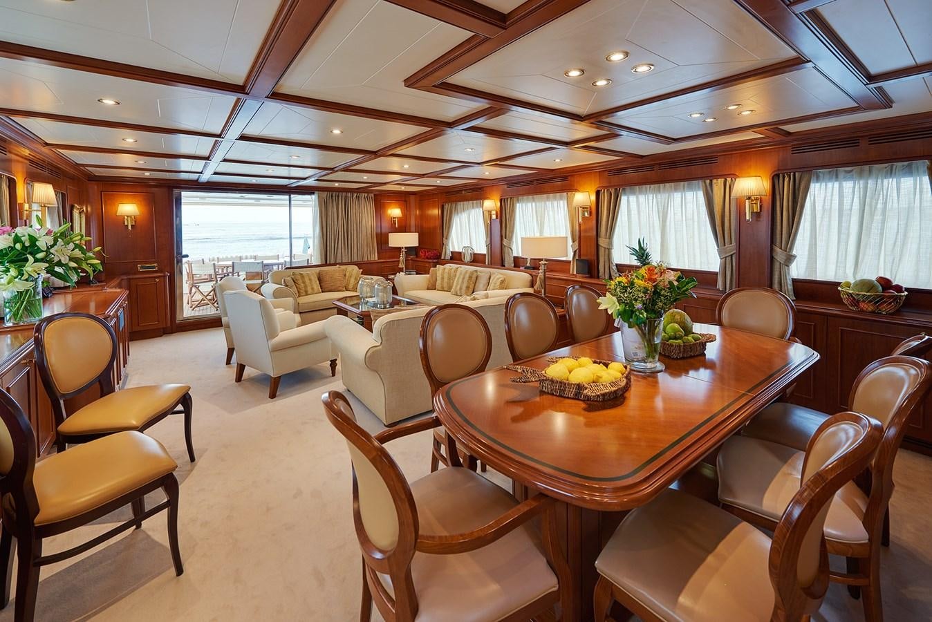 a large dining room with a wood table and chairs aboard IMAGINE Yacht for Charter