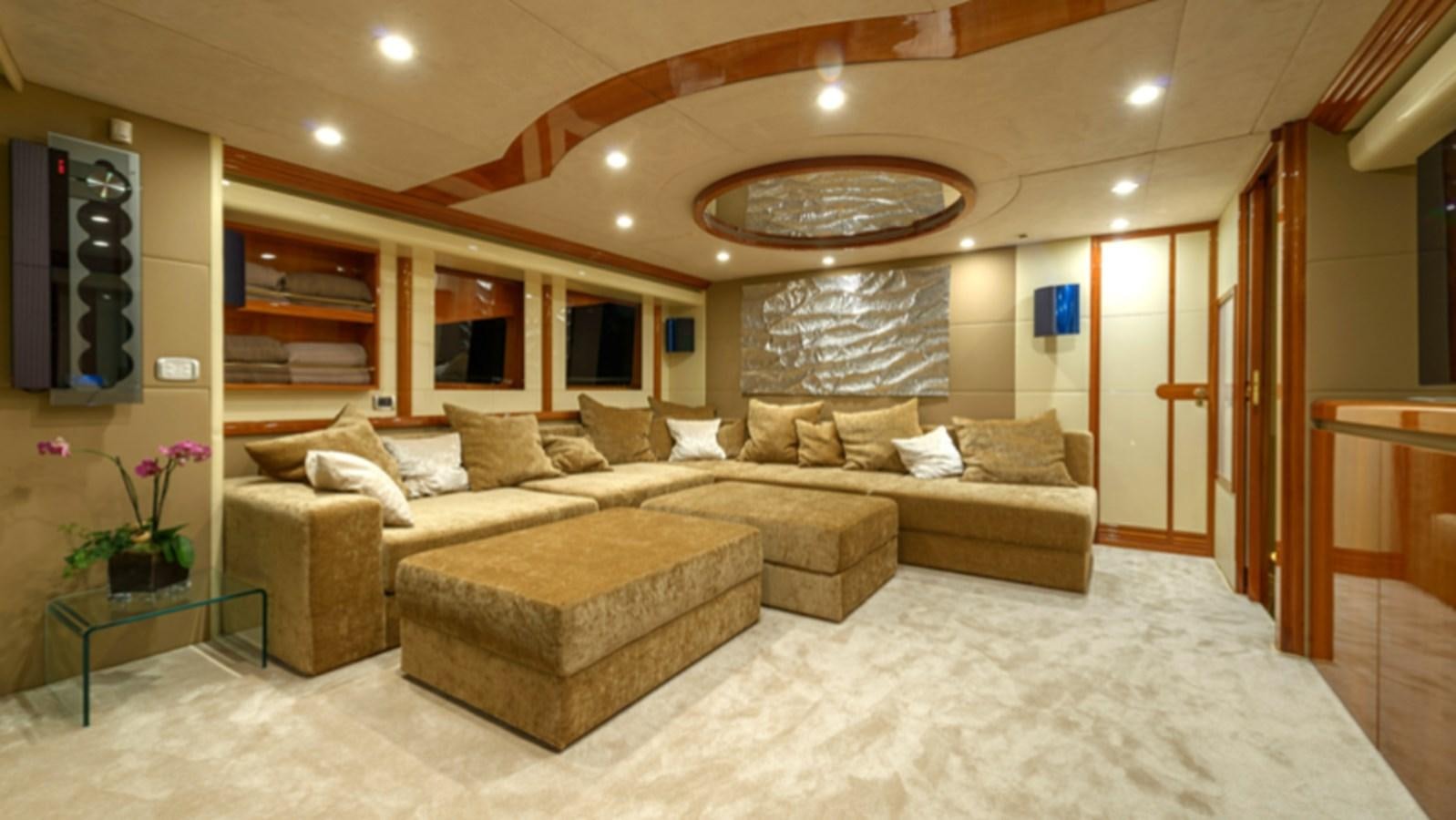 a large living room with a large sofa and a round table aboard NOVELA Yacht for Charter