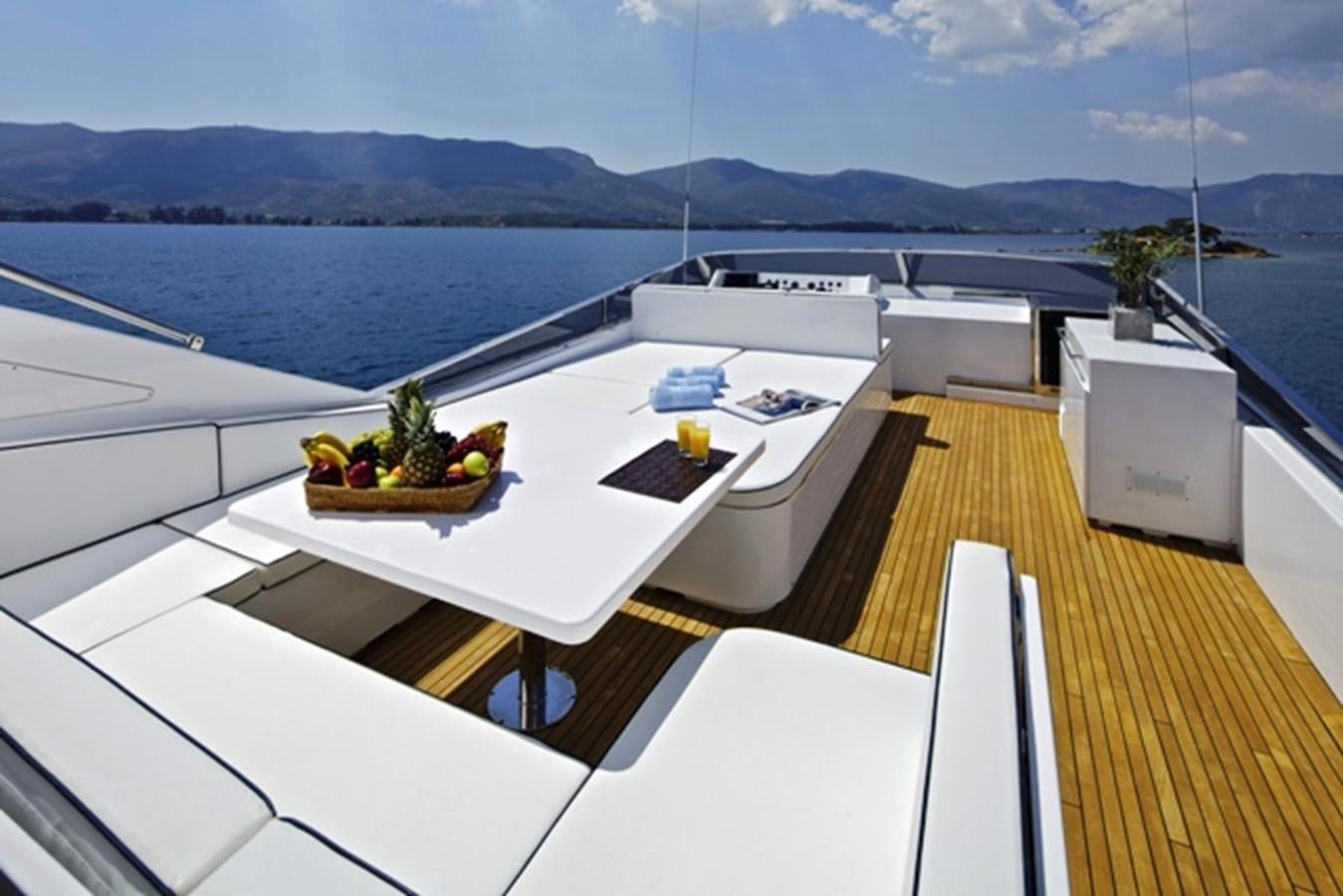 a deck with a table and chairs on it aboard GIOE I Yacht for Sale
