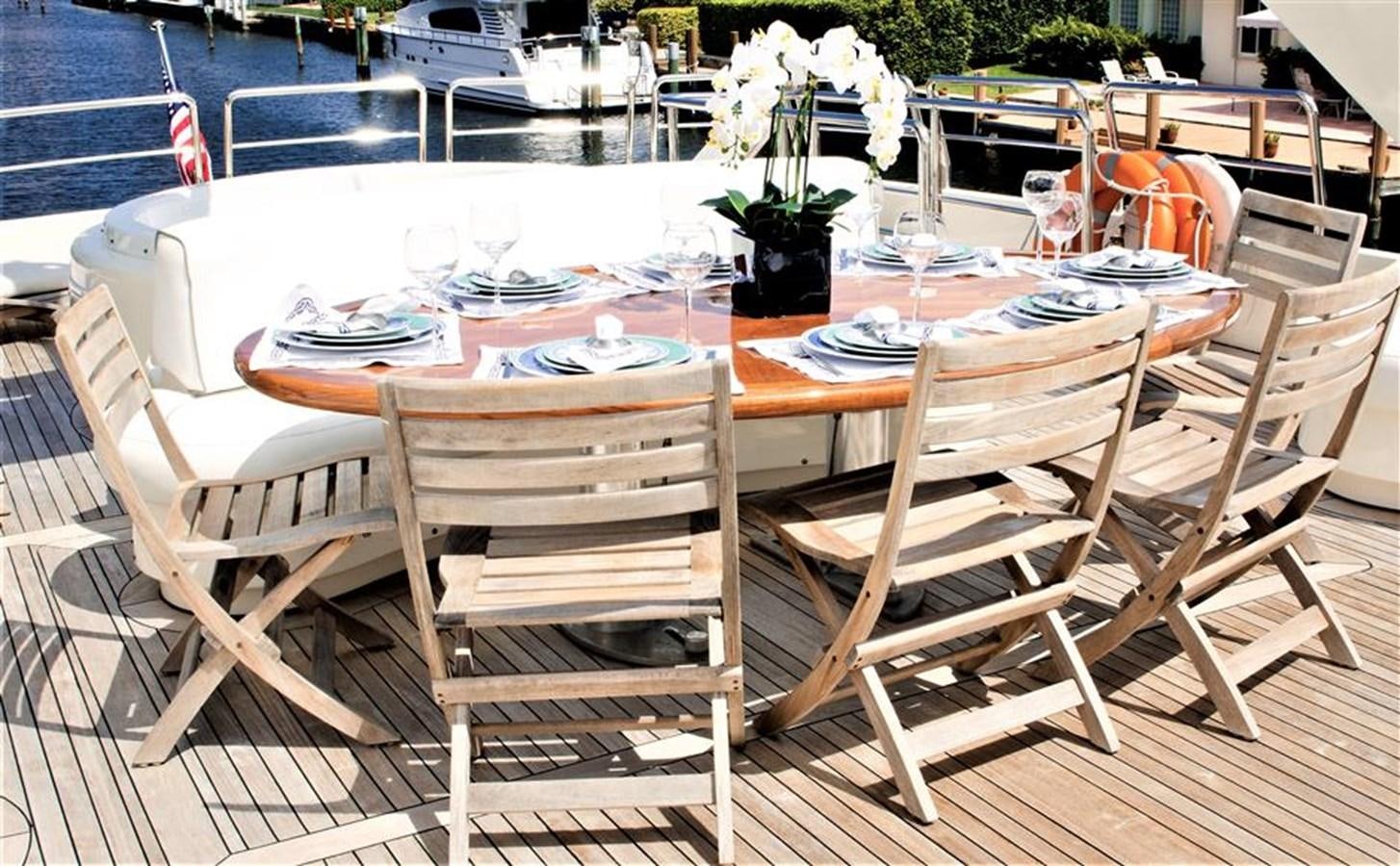 a table set with chairs and a table set for a dinner party aboard CAROBELLE Yacht for Sale