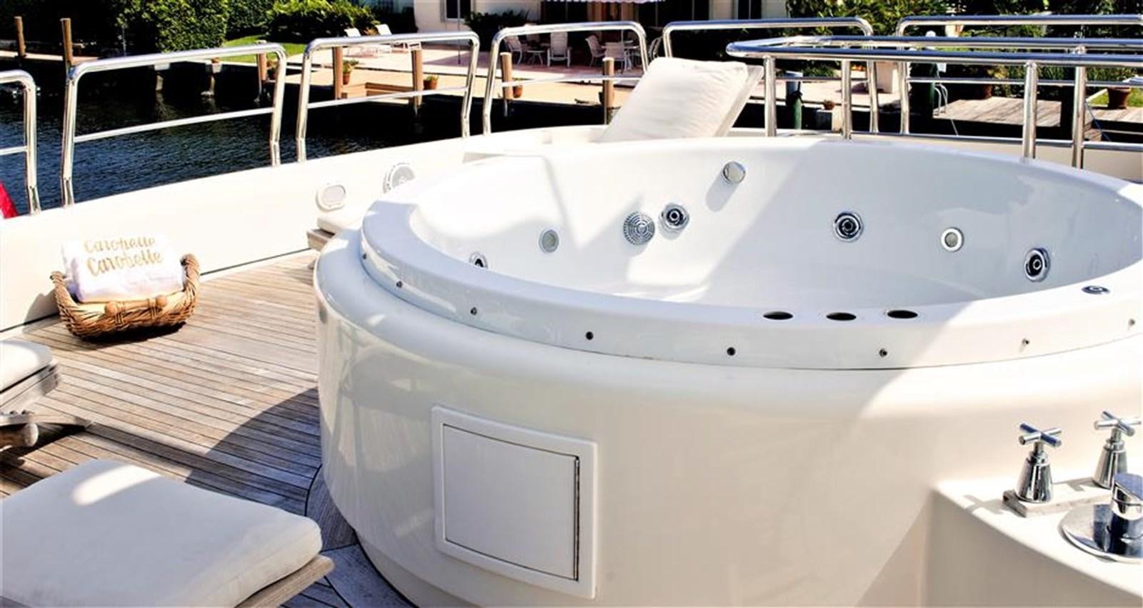 a large white bathtub with a sink and a basket on it aboard CAROBELLE Yacht for Sale