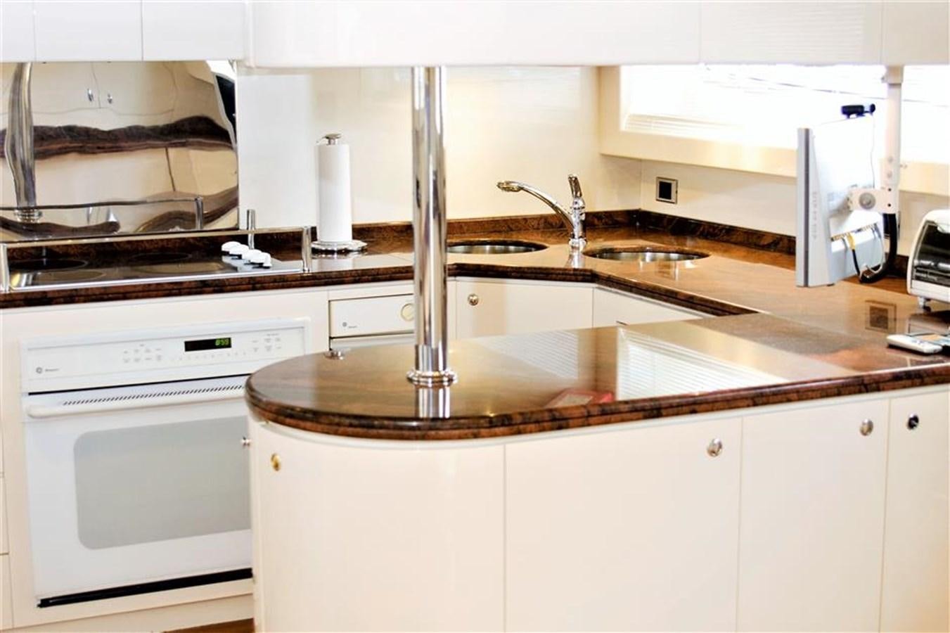 a kitchen with white cabinets aboard CAROBELLE Yacht for Sale