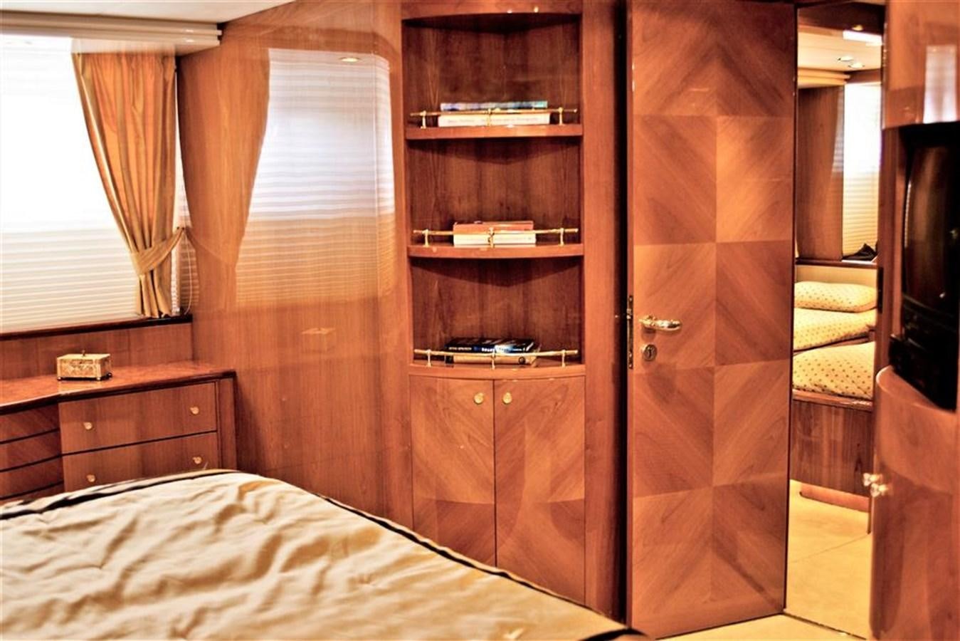 a bedroom with a bed and a shelf aboard CAROBELLE Yacht for Sale