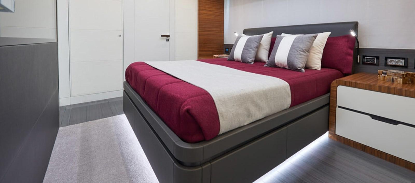 a bed with red sheets aboard AST100CENROY Yacht for Sale