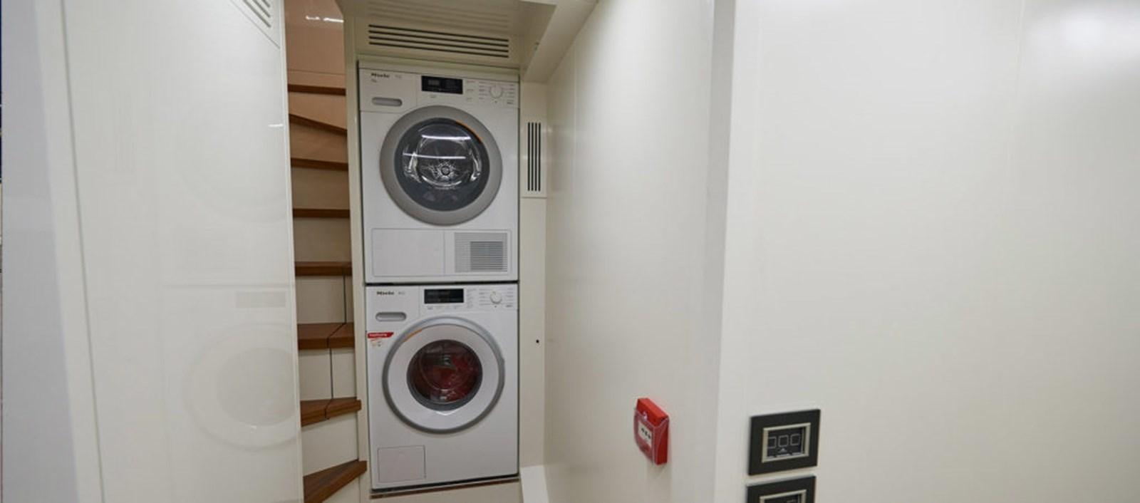 a white wall with a washing machine aboard AST100CENROY Yacht for Sale