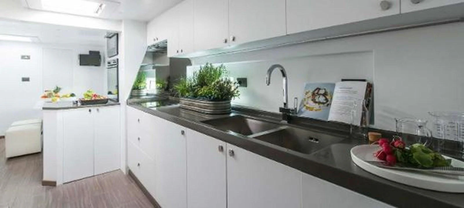 a kitchen with white cabinets aboard JAMADHAR Yacht for Sale