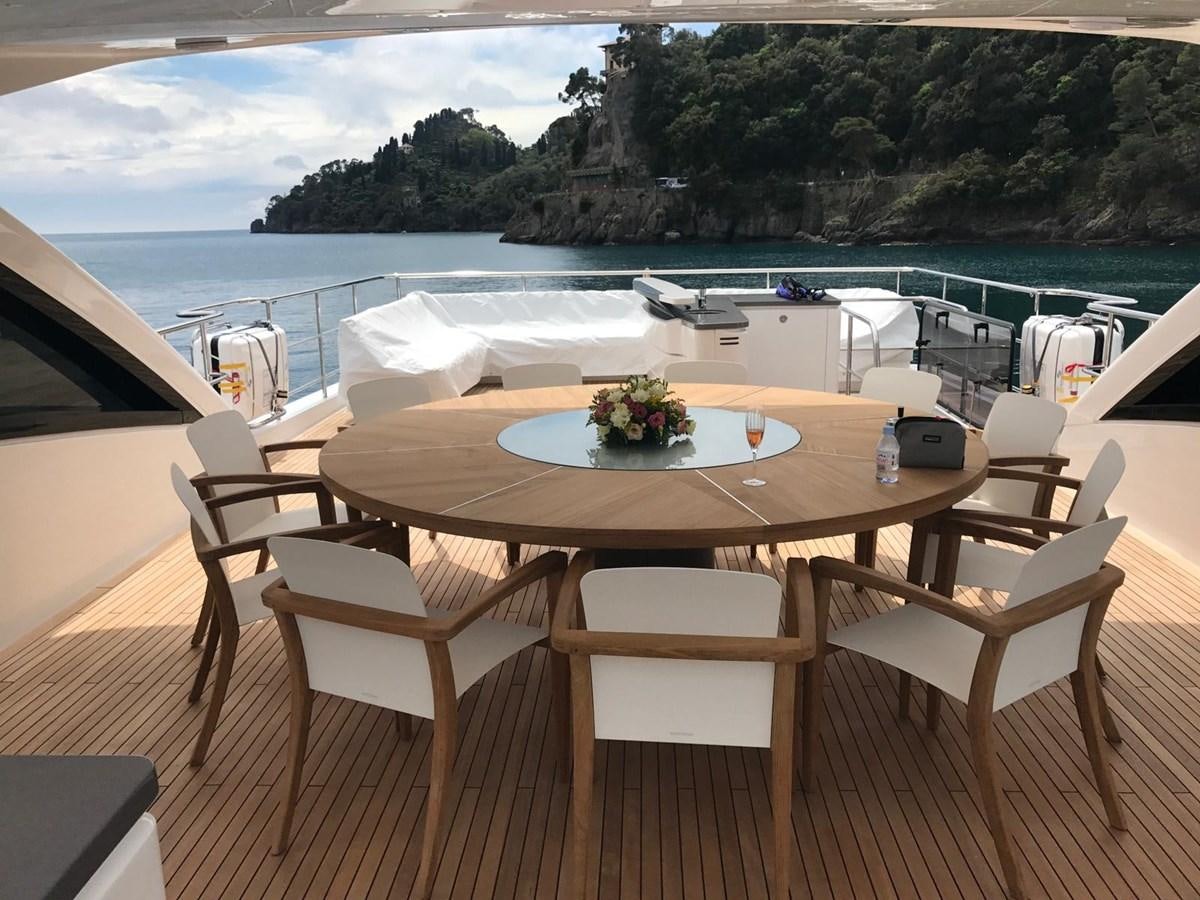 a table and chairs on a deck overlooking a body of water aboard THE SPIRIT OF ELIJAH Yacht for Sale