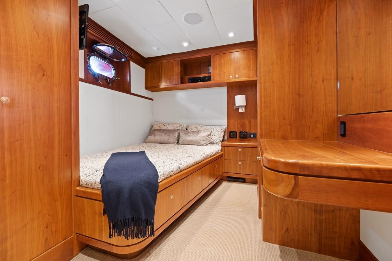 a bedroom with a bed and a wood cabinet aboard A.B. NORMAL Yacht for Sale