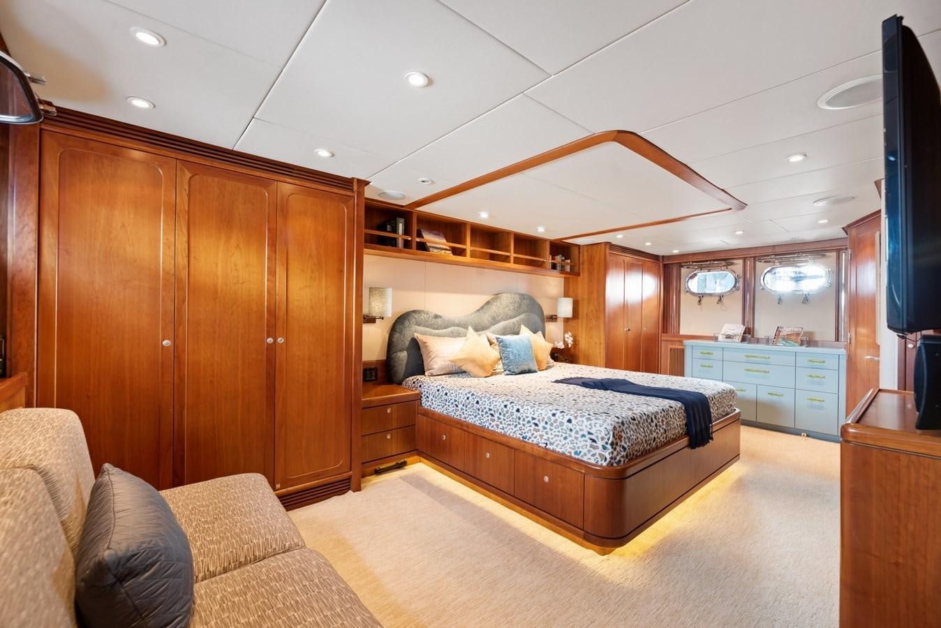 a bedroom with a bed and a wood cabinet aboard A.B. NORMAL Yacht for Sale