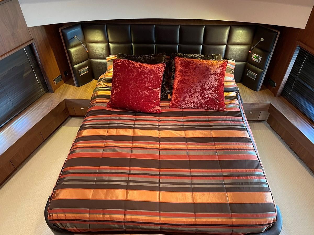a bed with a colorful comforter aboard SUNSEEKER 30M Yacht for Sale