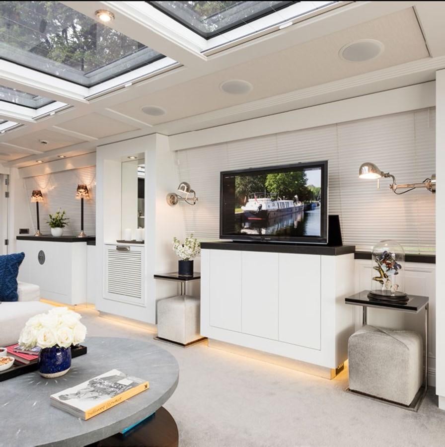 a living room with a tv aboard BARGE SAVVY Yacht for Sale