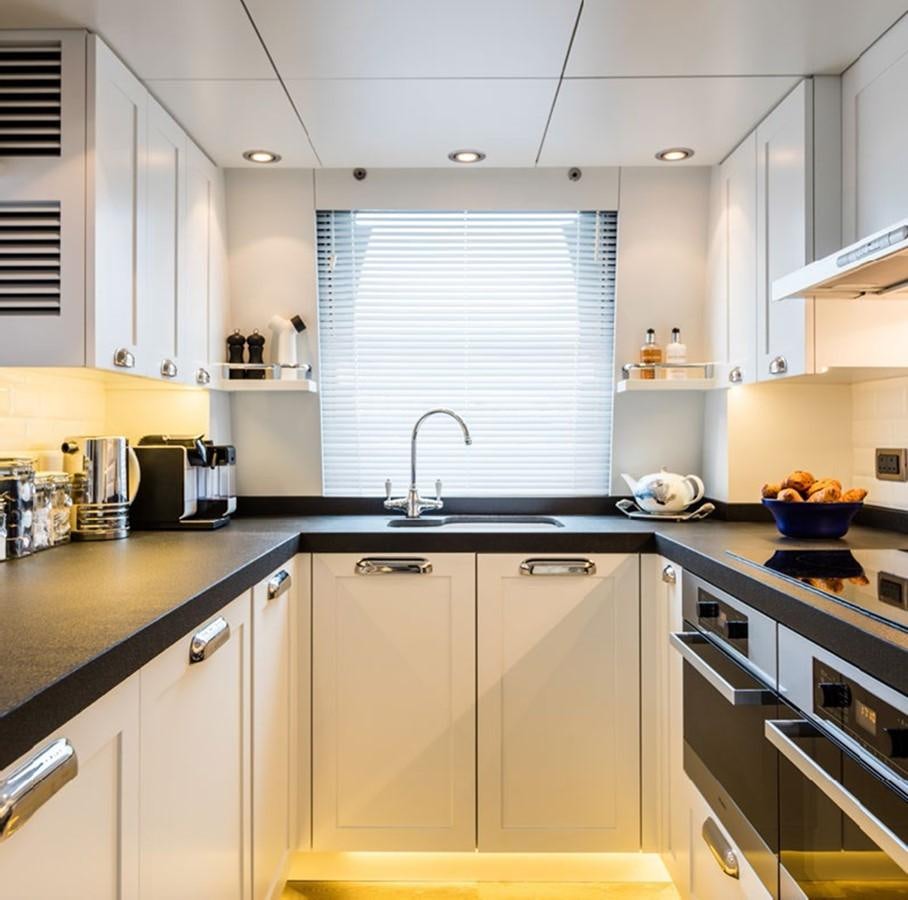 a kitchen with white cabinets aboard BARGE SAVVY Yacht for Sale