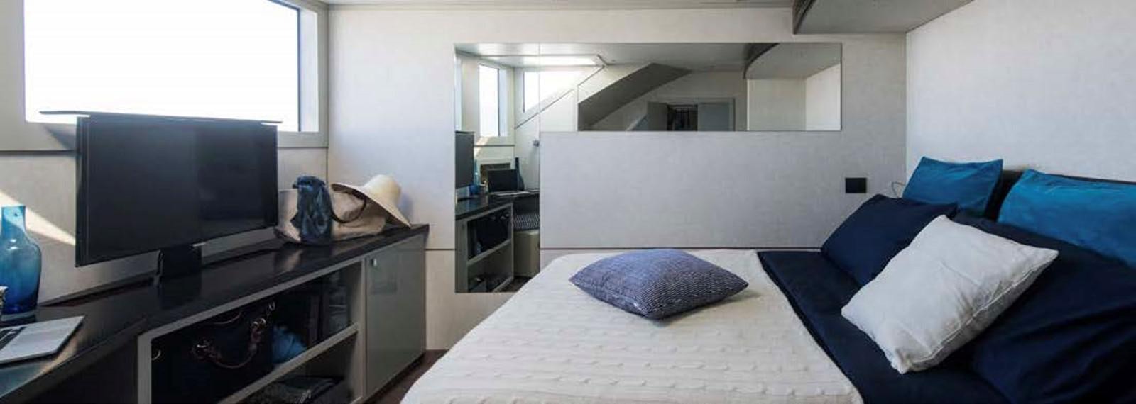 a bedroom with a bed and a tv aboard JAMADHAR Yacht for Sale