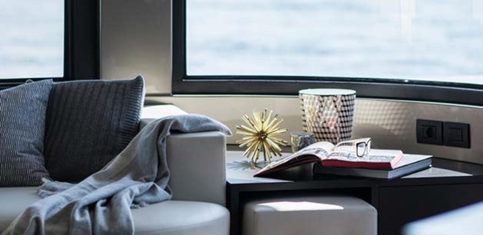 a living room with a coffee table and a vase with flowers aboard JAMADHAR Yacht for Sale