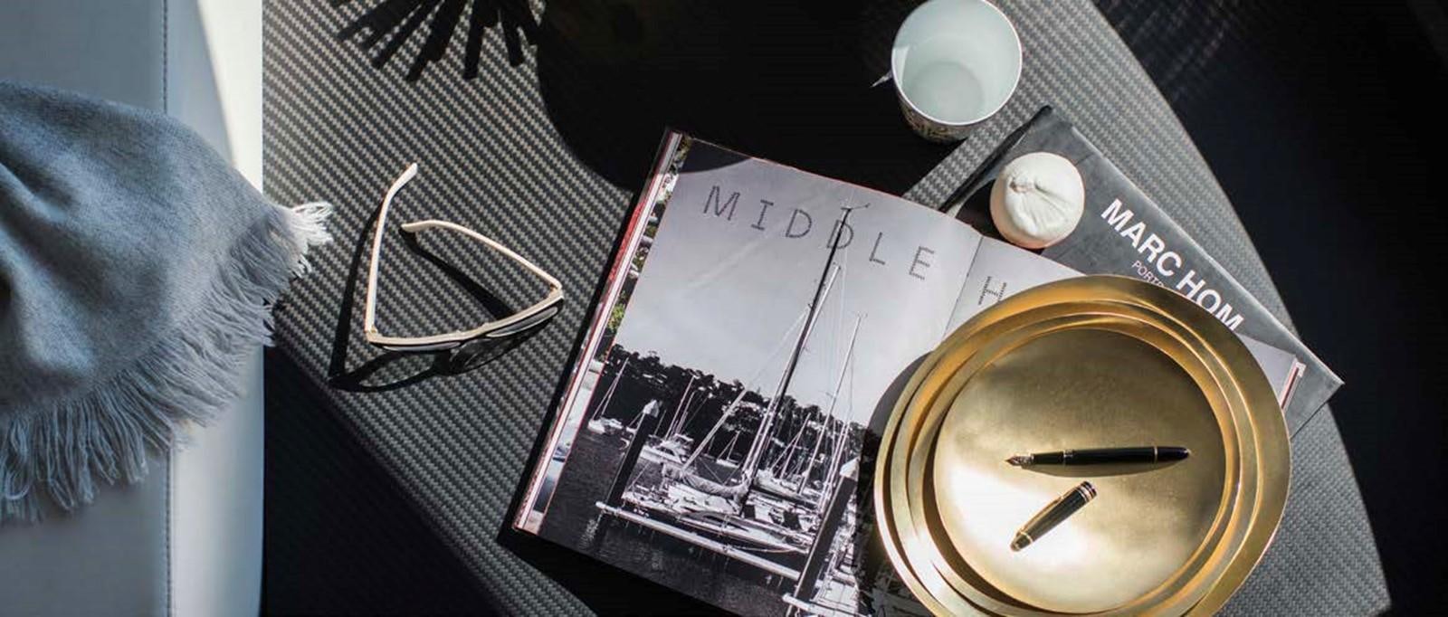 a book and a pen on a table aboard JAMADHAR Yacht for Sale