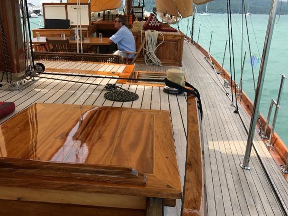 a person working on a wood table aboard 95FT 2011 CUSTOM KETCH CLASSIC YACHT Yacht for Sale