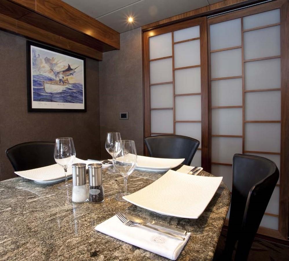 a table with wine glasses and napkins on it aboard PACIFIC HQ Yacht for Sale