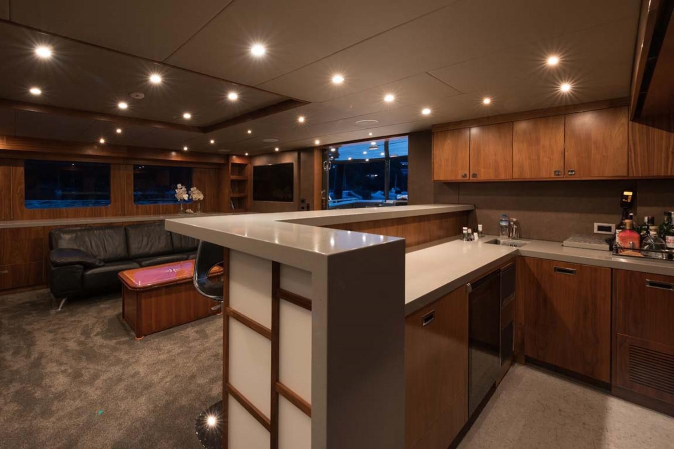 a kitchen with a bar and a couch aboard PACIFIC HQ Yacht for Sale