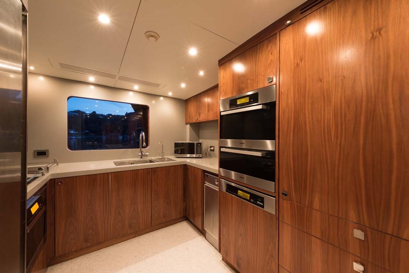 a kitchen with wooden cabinets aboard PACIFIC HQ Yacht for Sale