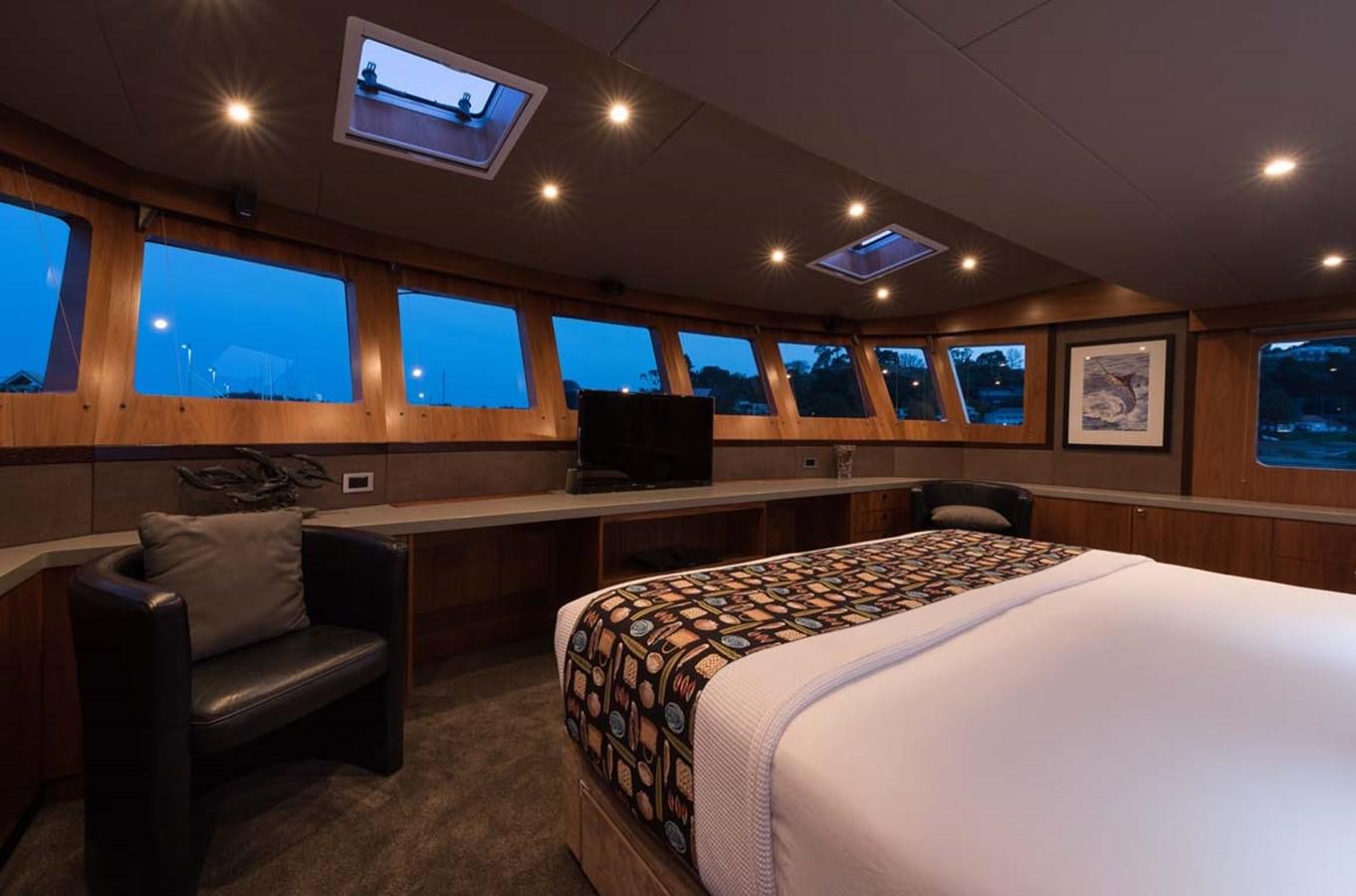 a room with a bed and a chair aboard PACIFIC HQ Yacht for Sale