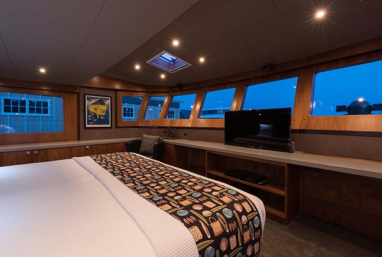 a room with a bed and a tv aboard PACIFIC HQ Yacht for Sale