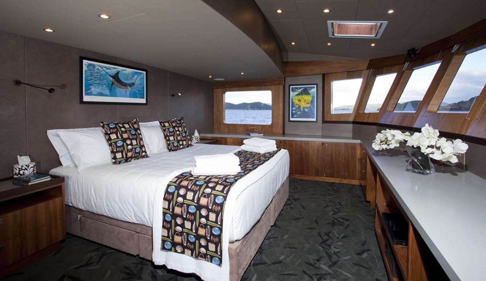 a room with a bed and a table aboard PACIFIC HQ Yacht for Sale