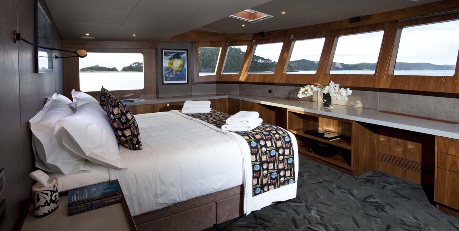 a room with a bed and a desk aboard PACIFIC HQ Yacht for Sale