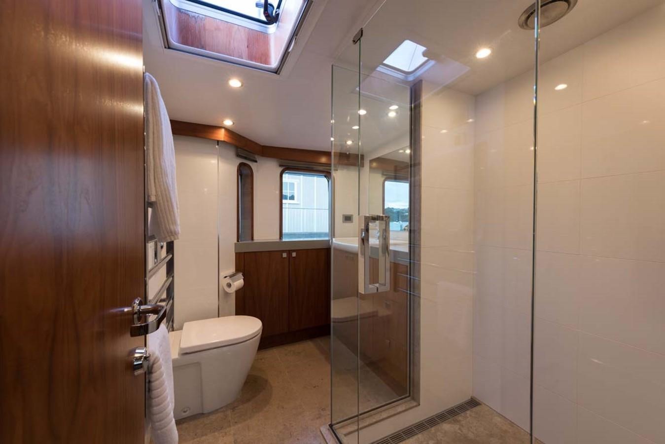 a bathroom with a glass shower aboard PACIFIC HQ Yacht for Sale