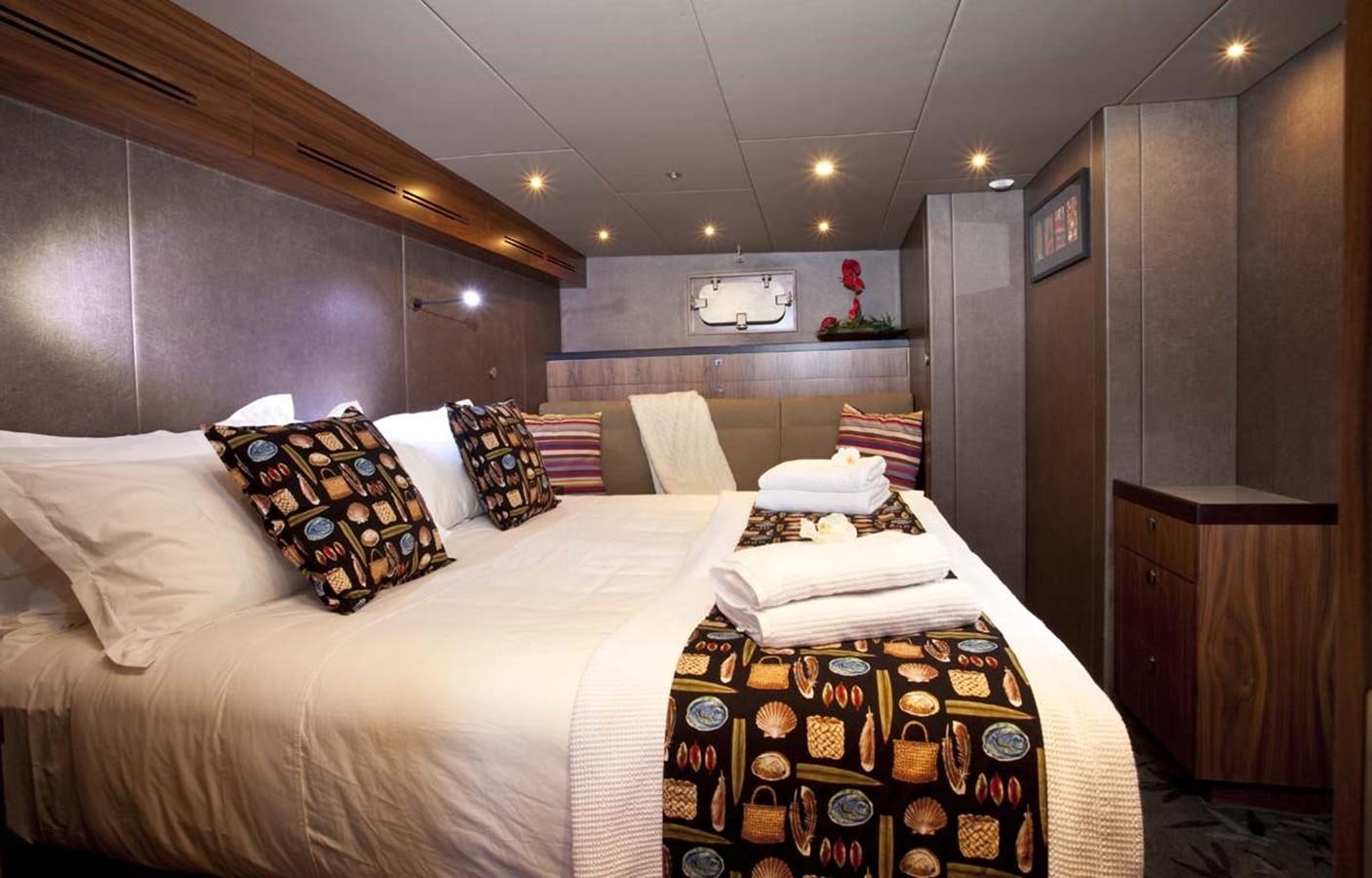 a room with a bed and a table aboard PACIFIC HQ Yacht for Sale