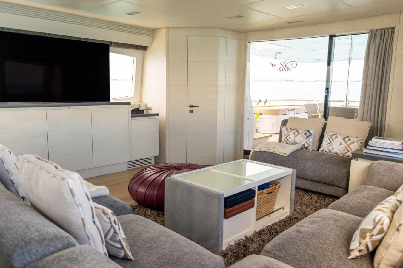 a living room with a tv and couches aboard VITA XL Yacht for Sale